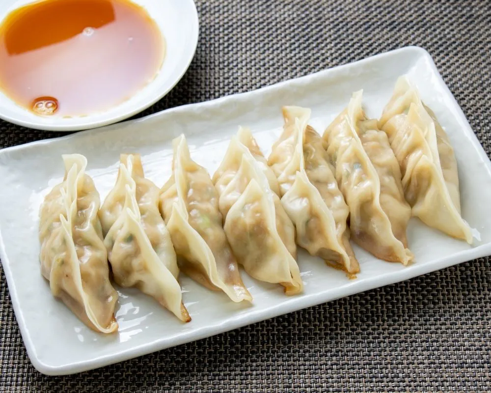Pan-fried dumplings with dipping sauce at ZOEN RAMEN & POKE, Ramen Restaurant in College Station