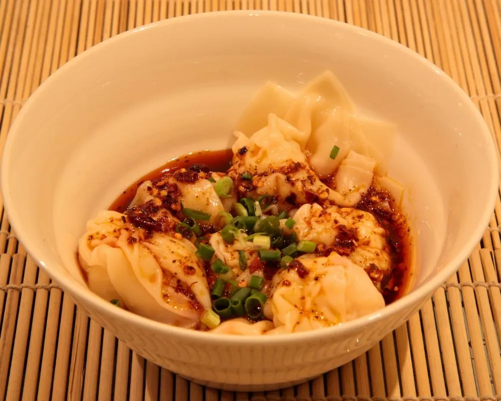 Spicy wontons in chili oil with scallions at ZOEN RAMEN & POKE, Ramen Restaurant in College Station