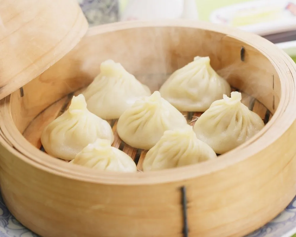 Steamed soup dumplings in bamboo steamer at ZOEN RAMEN & POKE, Ramen Restaurant in College Station